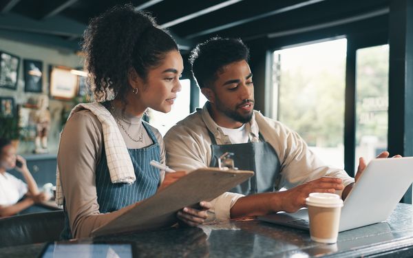 Ein Mann und eine Frau planen am Laptop das weitere Vorgehen in ihrer Bäckerei.