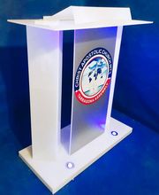 Atril blanco con el logotipo de "Christ Apostolic Church Int'l Tarragona Assembly".