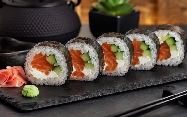 Futo Maki gefüllt mit Lachs, Gurke und Frischkäse, auf einer Schieferplatte.