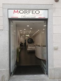 Ingresso di un negozio con insegna "Morfeo" e "Benvenuti", interni moderni e luminosi.