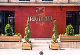 Fachada roja del Hotel Iriguibel con plantas decorativas y entrada principal.