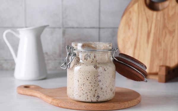 Ein Sauerteigstarter steht mit geöffnetem Deckel in einer Küche.