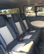 Asientos traseros de una camioneta con tres plazas y ventanas a los lados.