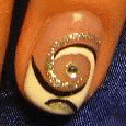Nageldesign mit spiralförmigem Muster und Glitzer auf blauem Hintergrund.