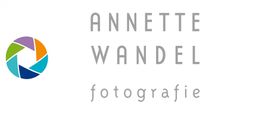 Logo mit Regenbogenkamera und Text "Annette Wandel Fotografie" in grauer Schrift.