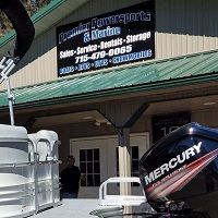 Exterior of a Powersports and Marine store with a Mercury outboard motor display.