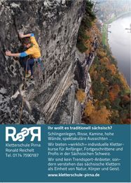 Kletterer an einer steilen Felswand; herbstliche Landschaft und Fluss im Hintergrund.