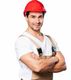 Man in a red hard hat and overalls smiling with arms crossed, isolated on a white background.