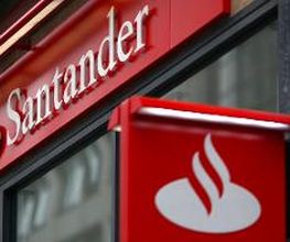 Fachada de uma agência do banco Santander com logo vermelho e branco na entrada.