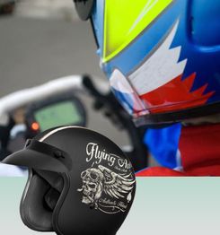 Close-up of colorful helmet and black helmet with "Flying Ace" design, motorcycle in the background.