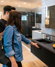 Due persone guardano mobili e lavandino in un negozio di arredamento moderno.