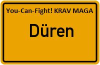 Gelbes Schild mit "You-Can-Fight! KRAV MAGA" und "Düren" in der Mitte.