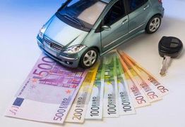 Kleines Auto mit Euroscheinen und Autoschlüssel auf weißem Hintergrund.