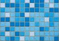 Blue mosaic tile pattern with various shades, creating a textured geometric design.
