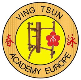 Emblem der Ving Tsun Academy Europe mit Holzpuppe und roten chinesischen Schriftzeichen.