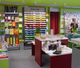 Papierladen mit buntem Papierregal, Geschenktüten und Karten.