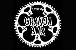 Logo de Granja BMX Tenerife con una rueda dentada negra y texto blanco al centro.