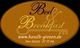 Ovales Schild "Bed & Breakfast" mit Website und Telefonnummer auf braunem Hintergrund.