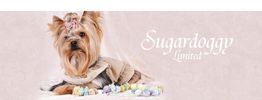 Yorkshire-Terrier mit rosa Schleife und Mantel liegt vor Süßigkeiten und "Sugardoggy Limited" Text.