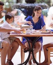 Familia desayunando en un restaurante con alegría.