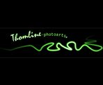Grüner, welliger Lichtschriftzug auf schwarzem Hintergrund, Text: "Thomline photoarts".