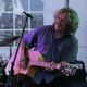 Mann spielt Gitarre und singt leidenschaftlich auf der Bühne.