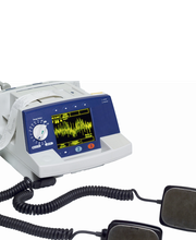 Defibrillatore medico con elettrodi e schermo che mostra tracciato cardiaco.