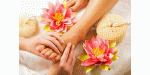 Fußmassage mit rosa Lotusblüten und Handtuch auf einem weißen Hintergrund.