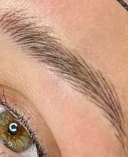 Close-up van een groen oog met lange wimpers en een goed gevormde wenkbrauw.