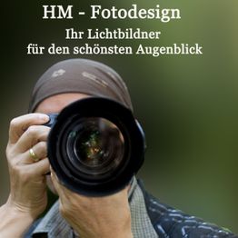 Fotograf mit Kamera, Text oben: "HM - Fotodesign, Ihr Lichtbildner für den schönsten Augenblick".