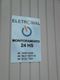 Placa da Eletrowal em parede, com contatos de monitoramento 24 horas e números de telefone.