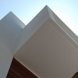 Estructura geométrica blanca con cielo azul de fondo.