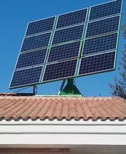Panel solar grande sobre un tejado de tejas rojas en un día soleado con cielo azul despejado.