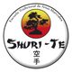 Logotipo de la Escuela Tradicional de Artes Marciales Shuri-Te con un árbol al atardecer.
