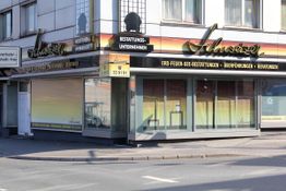 Eckgeschäft mit Schaufenstern und Beschriftung "Bestattungsunternehmen".
