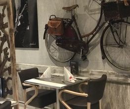 Zwei gedeckte Tische vor einer Wand mit dekorativem Fahrrad.