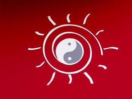 Yin-Yang-Symbol inmitten einer stilisierten Sonne auf rotem Hintergrund.