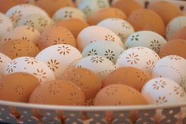 Verzierte Eier in Pastellfarben, dicht aneinandergereiht in einem Korb.