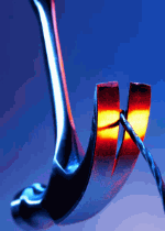 Gabel sticht in Draht vor blauem Hintergrund.