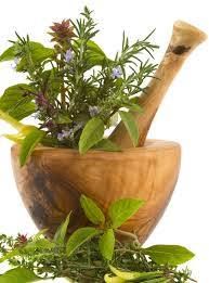 Mortaio in legno con erbe fresche verdi e fiori.
