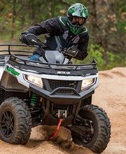 Persona conduciendo un vehículo todoterreno en arena, levantando polvo.