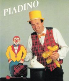 Ein Mann mit Hut zaubert ein Kaninchen aus einem Zylinder. Clownfigur und Luftballonfigur daneben.