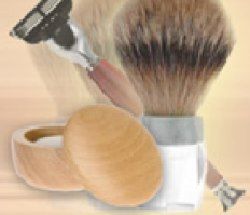 Rasierzubehör mit Pinsel, Rasierseife in Holzschale und Rasierhobel auf beigem Hintergrund.