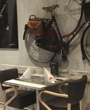 Zwei gedeckte Tische vor einer Wand mit dekorativem Fahrrad.