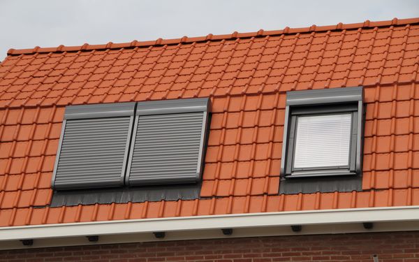 Dachfenster mit Verdunklungsmöglichkeiten, auf einen rostbraunen Dach.