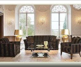 Elegantes Wohnzimmer mit Sofas, Glastisch, goldenen Lampen und großen Fensterbögen.