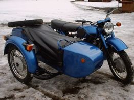 Blaues Motorrad mit Beiwagen steht auf schneebedecktem Boden.