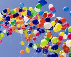 Bunte Luftballons fliegen in den blauen Himmel.