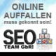 Text "Online auffallen muss gekonnt sein! SEO Team GbR" mit Social-Media-Logos auf Würfeln.