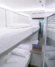 Cama beliche em cabina moderna e minimalista com luzes brancas.